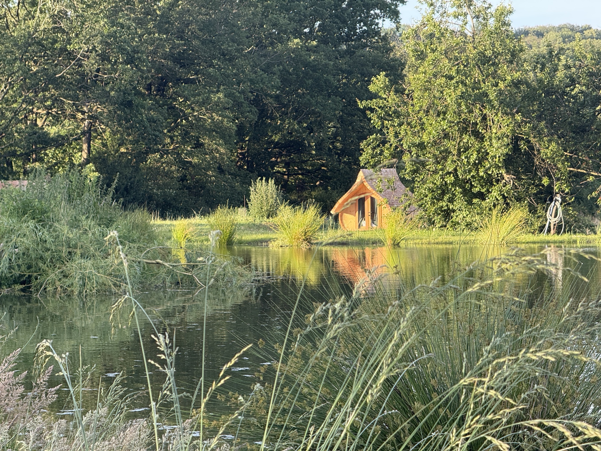 Das versteckte Teichhaus, über das Wasser gesehen