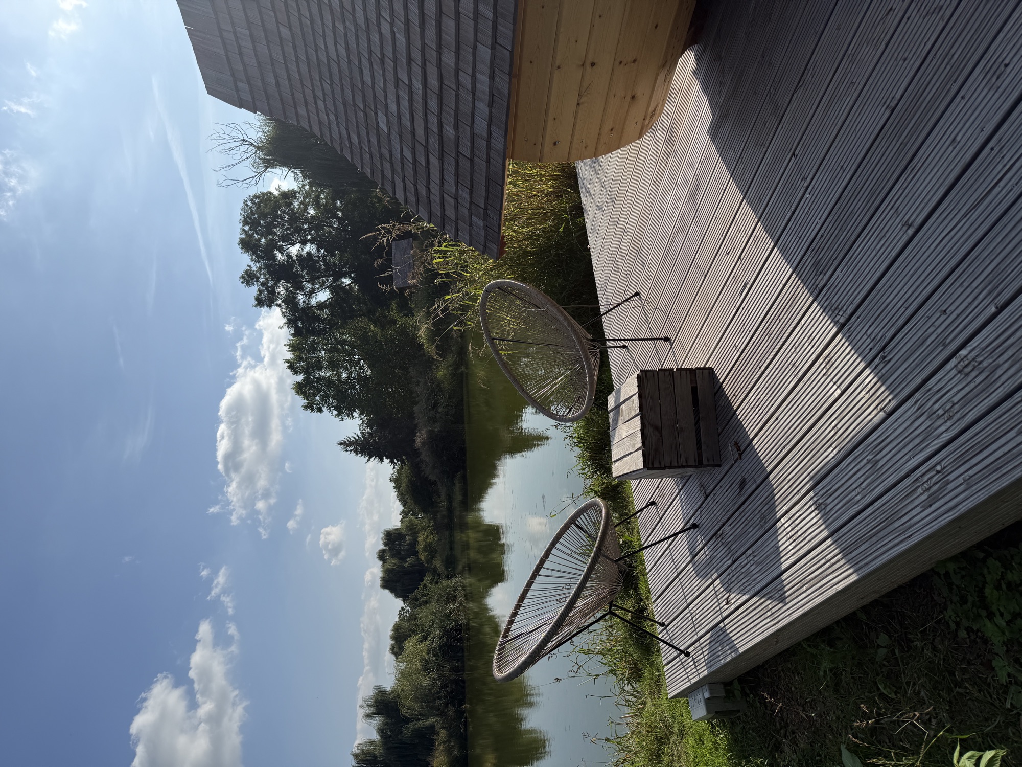 Steg und zwei Stühle vor dem Teichhaus