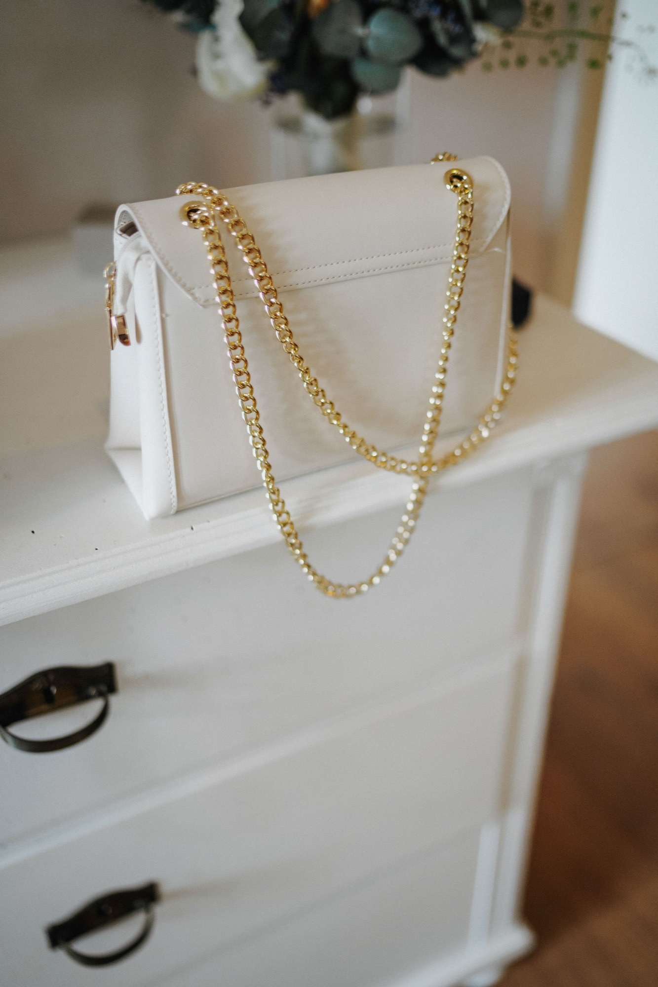 Goldene Kette an einer weißen Tasche