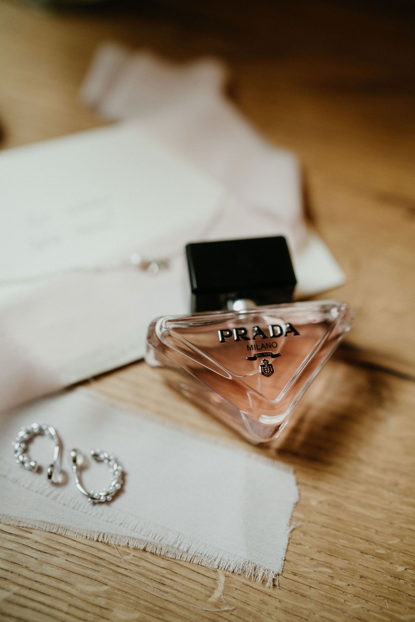 Parfum und Ohrringe auf dem Tisch